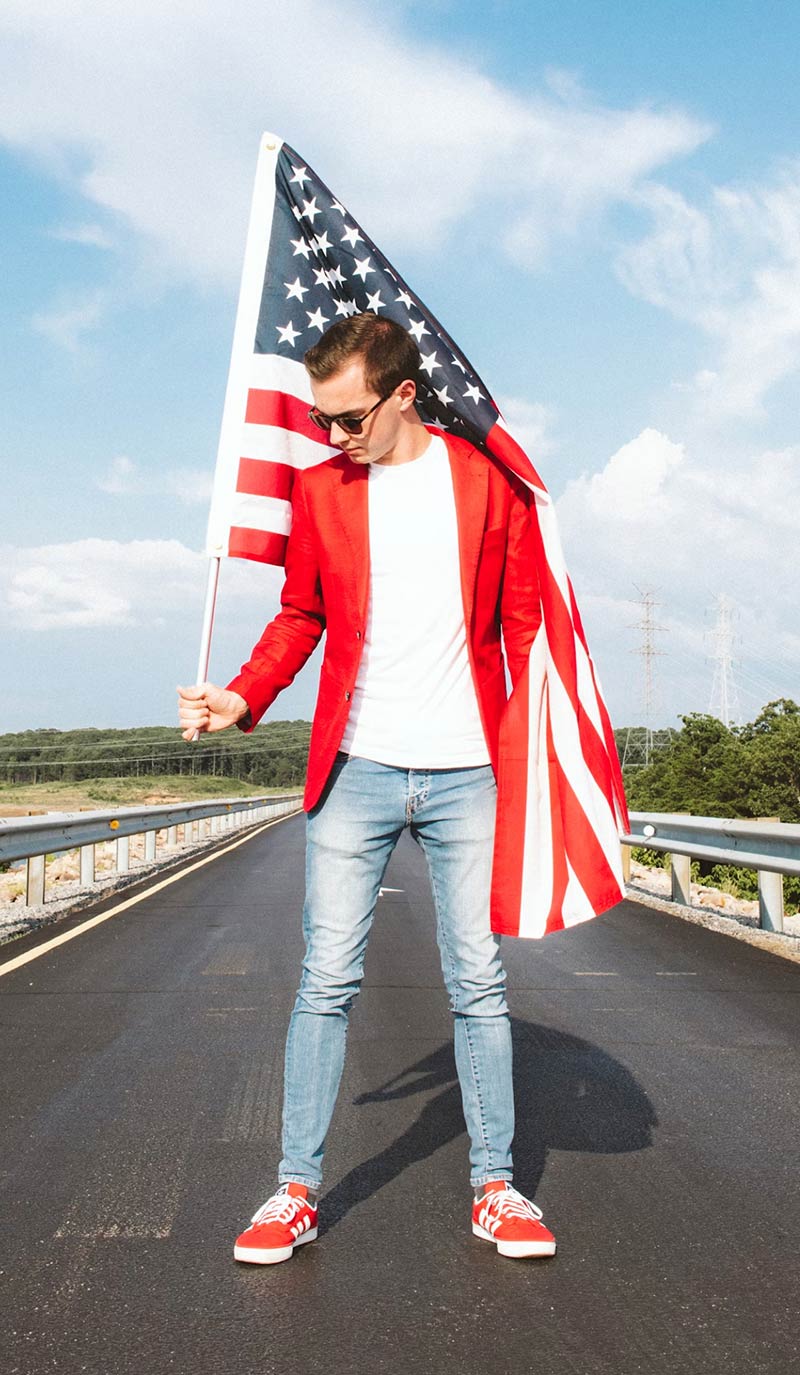 Man Standing in the Road with USA Flag